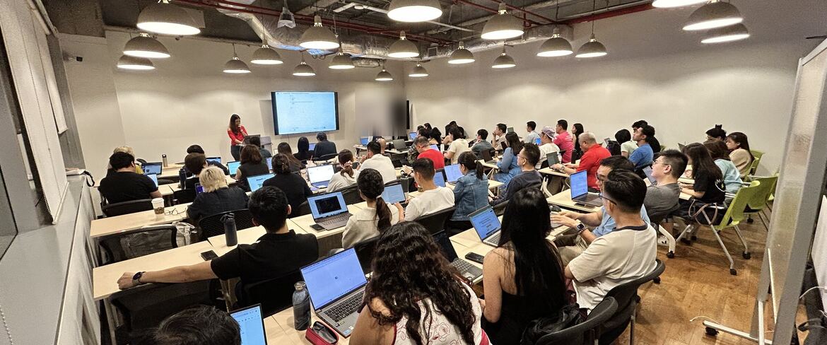 A full room of founders and operators with laptops open at an AI Power Users meetup in Singapore