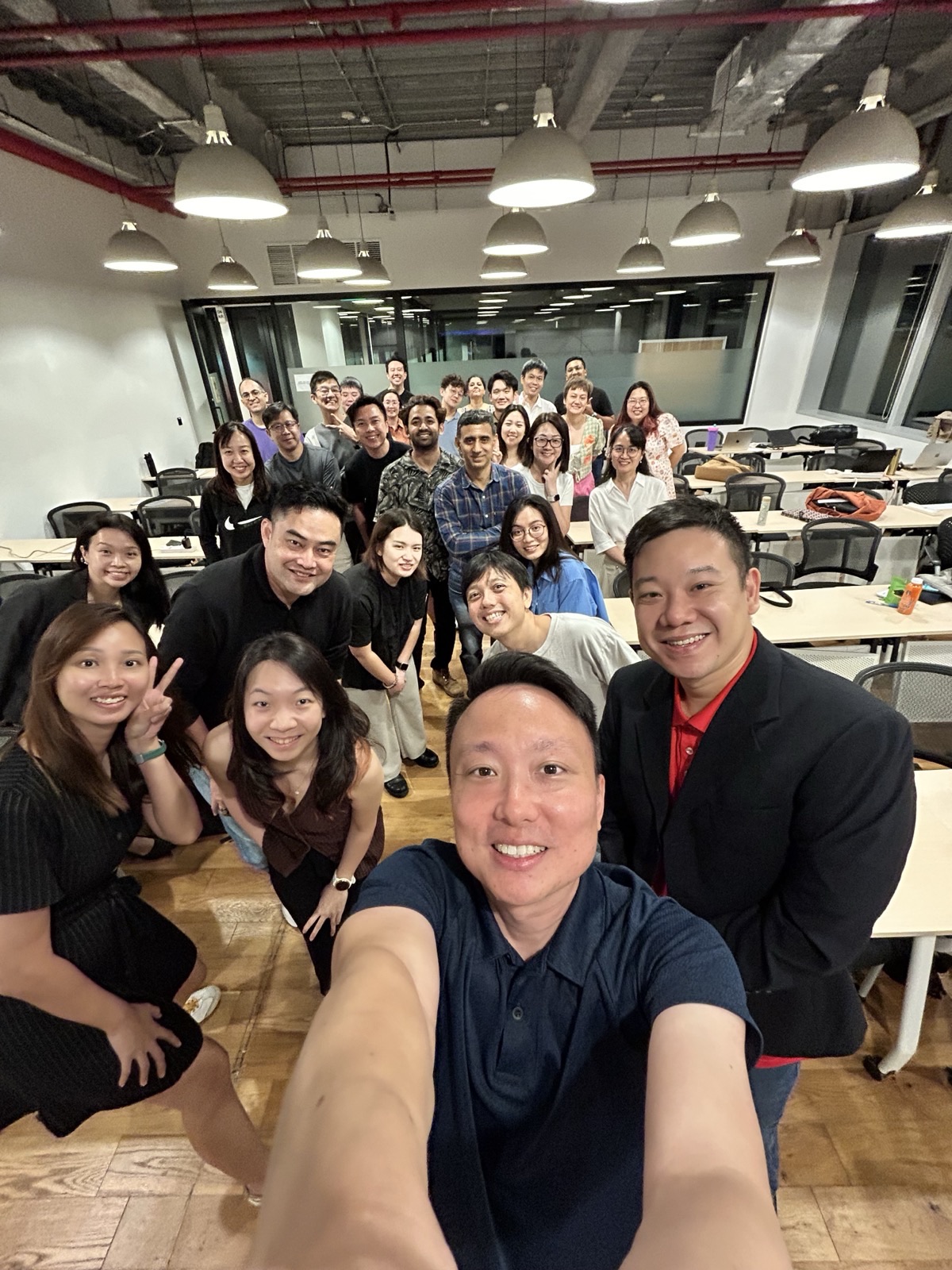 Keith Teo taking a group selfie with around twenty meetup attendees