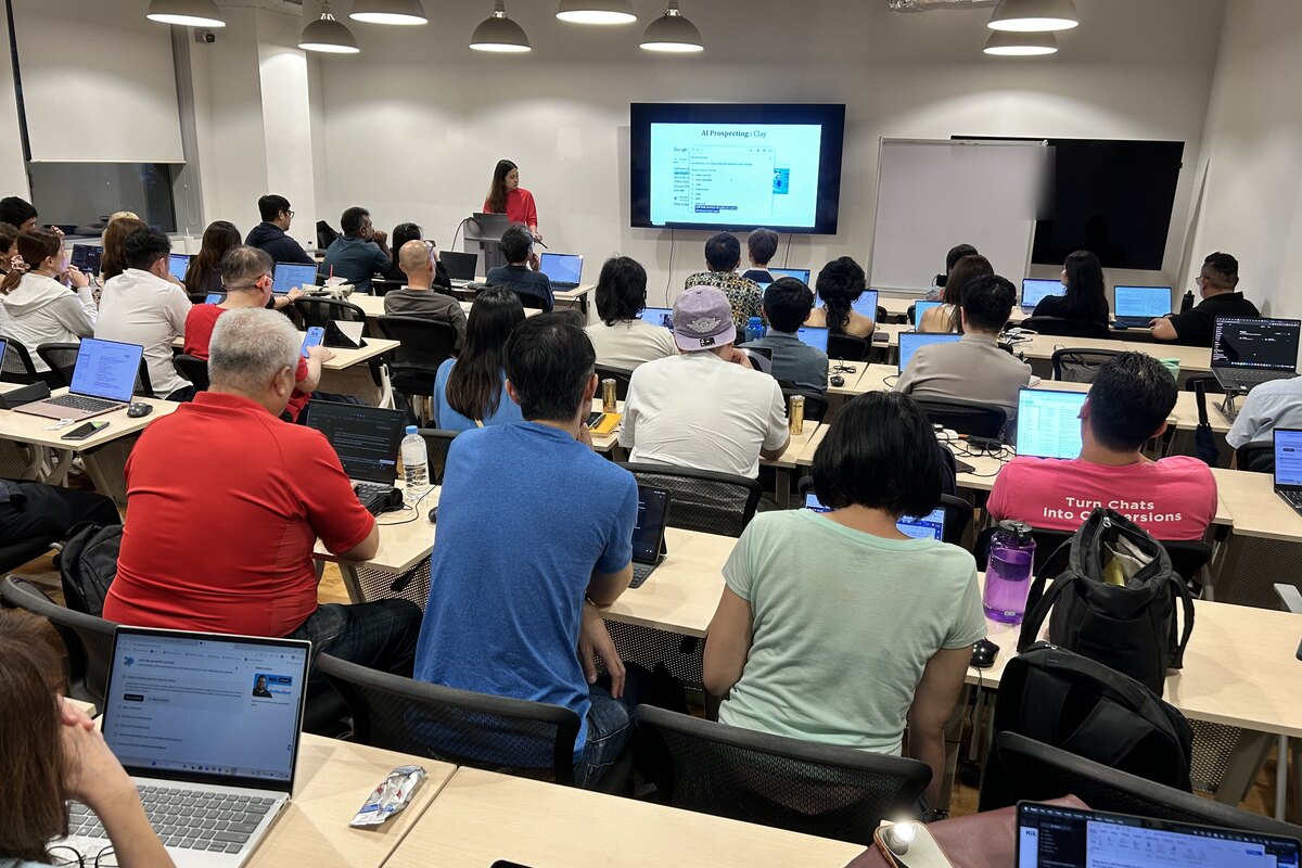 Community speaker Charmain presenting her cold outreach workflow to a full room at an AI Power Users meetup in Singapore