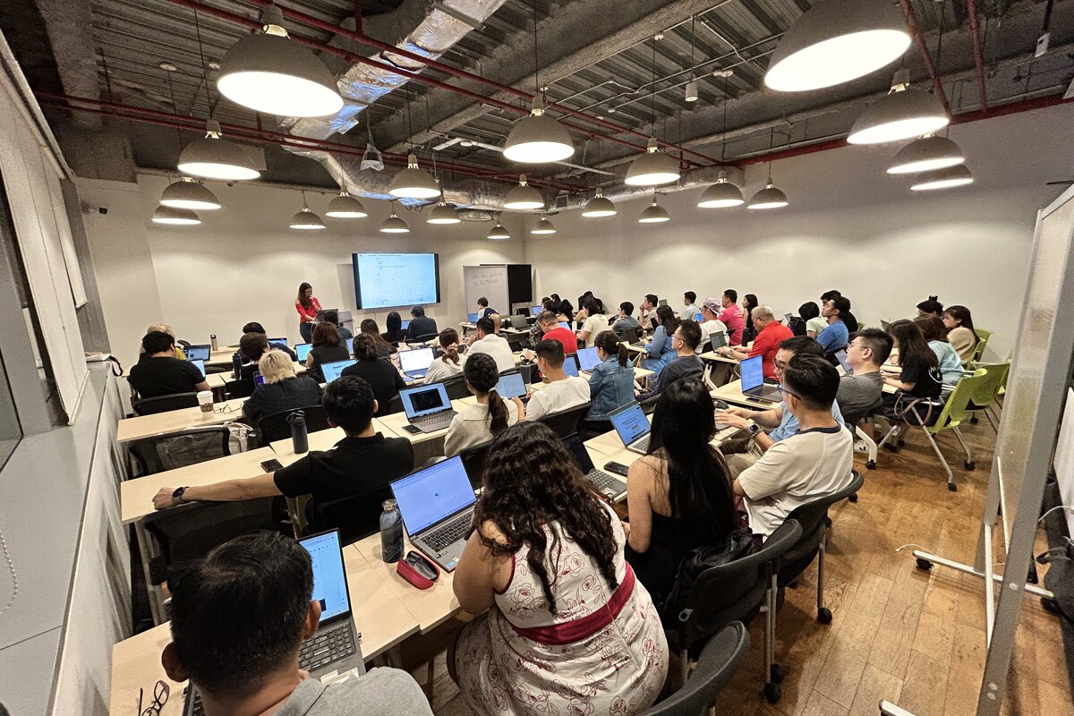 A full room of attendees with laptops open at AI Power Users Meetup 05 at ERC Institute, Singapore